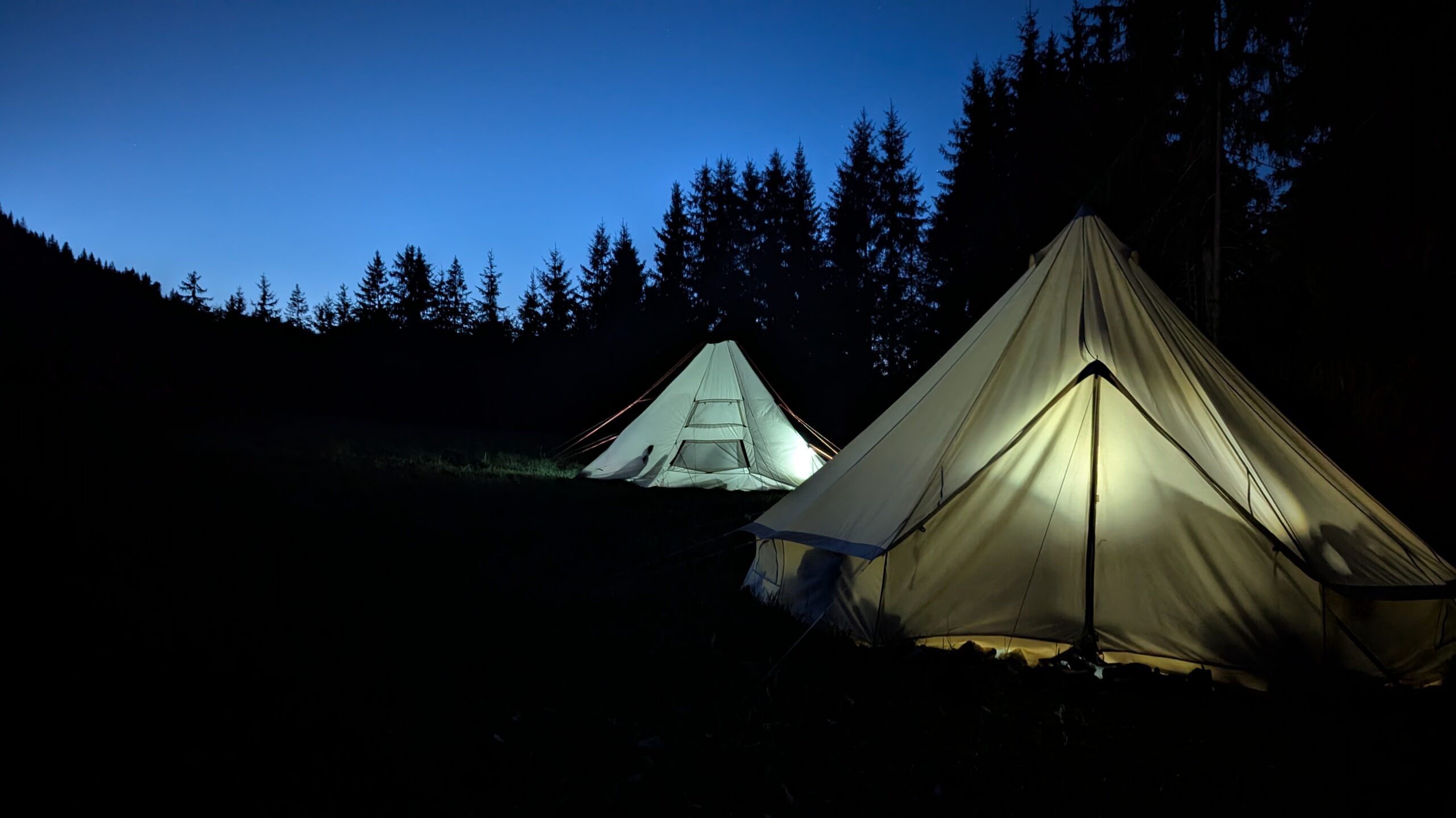 Tipis éclairés la nuit pendant le bivouac