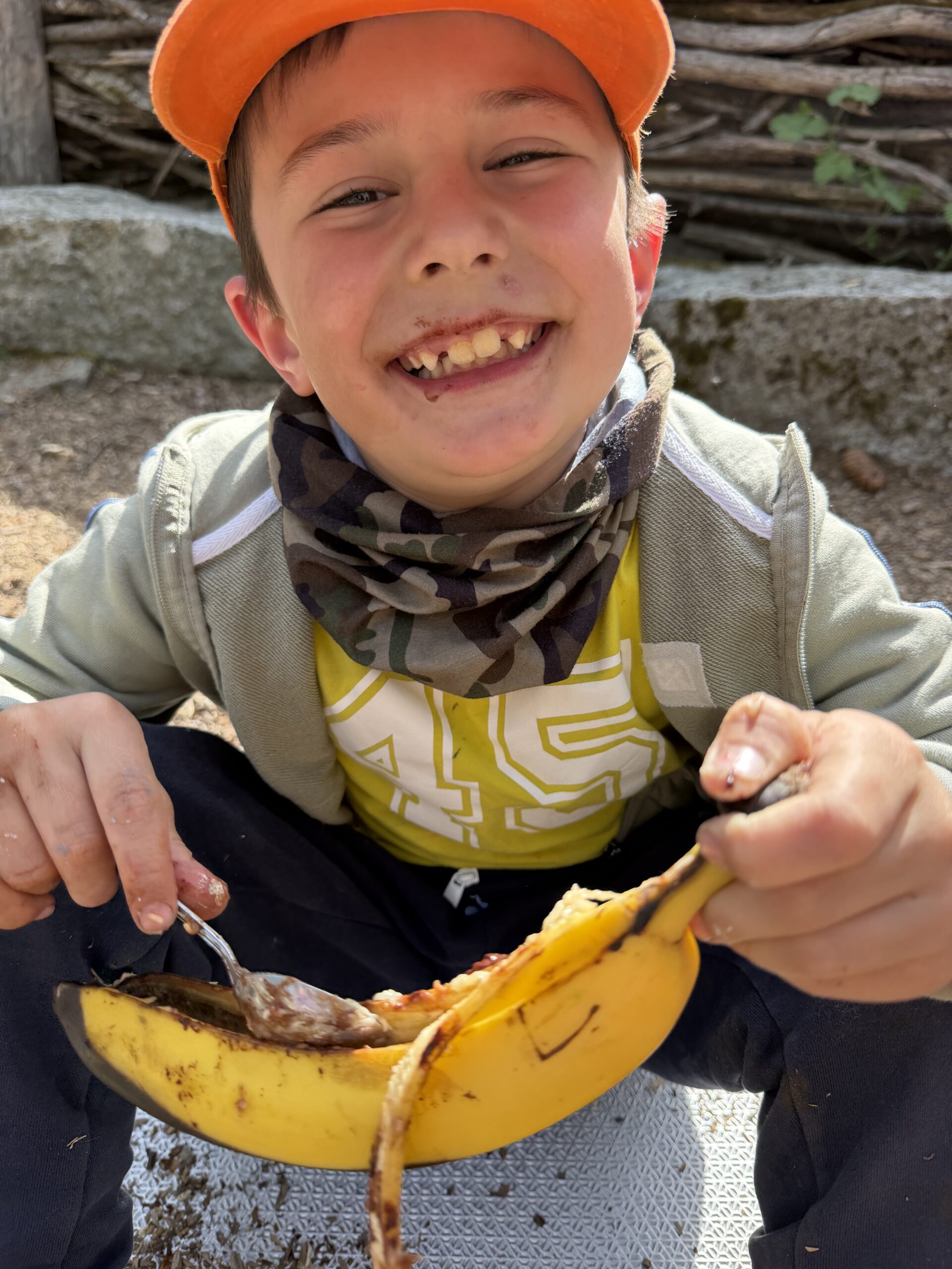 Un enfant souriant avec sa banane pendant le stage