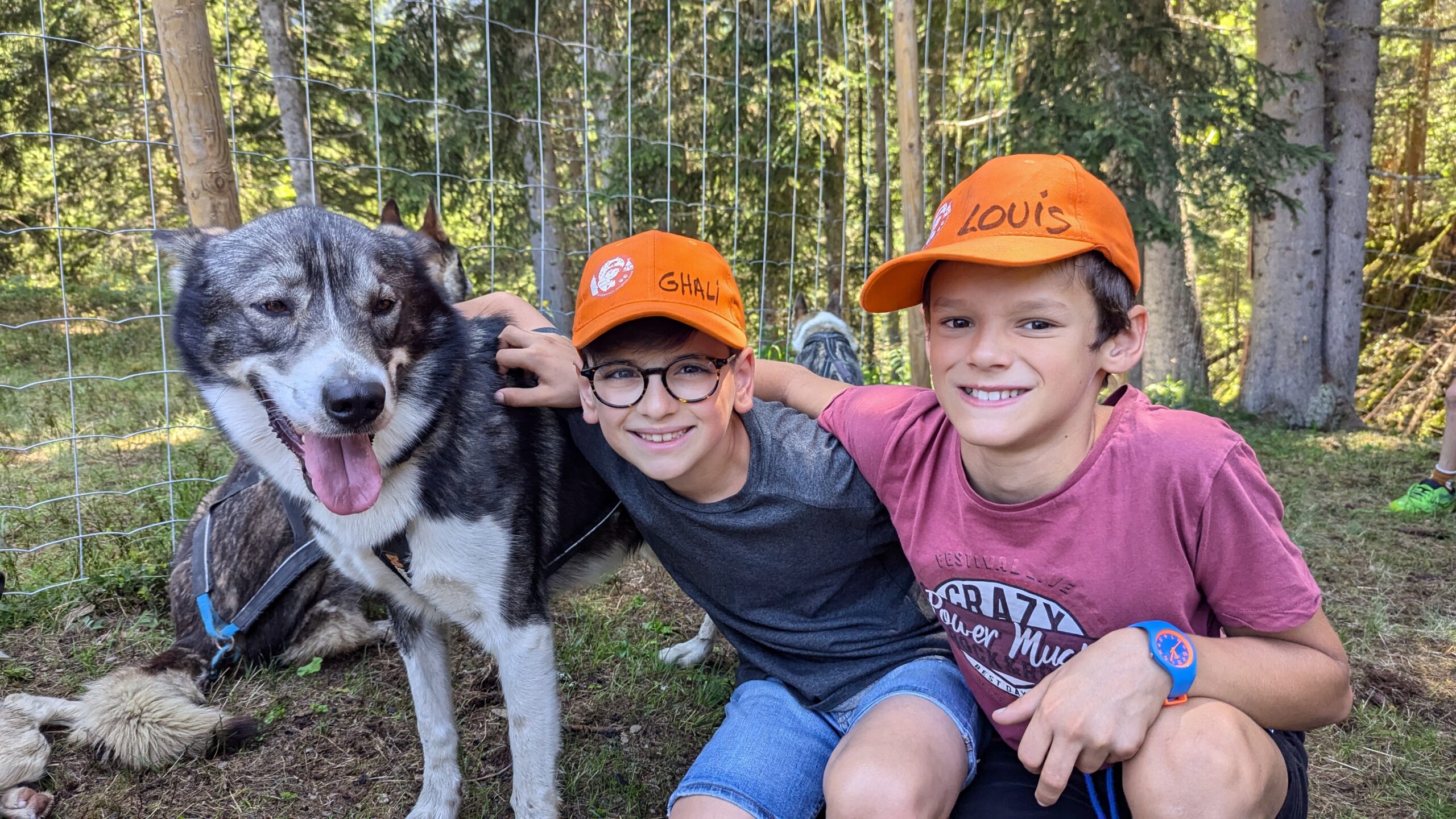 Deux enfants sourient à côté d’un chien