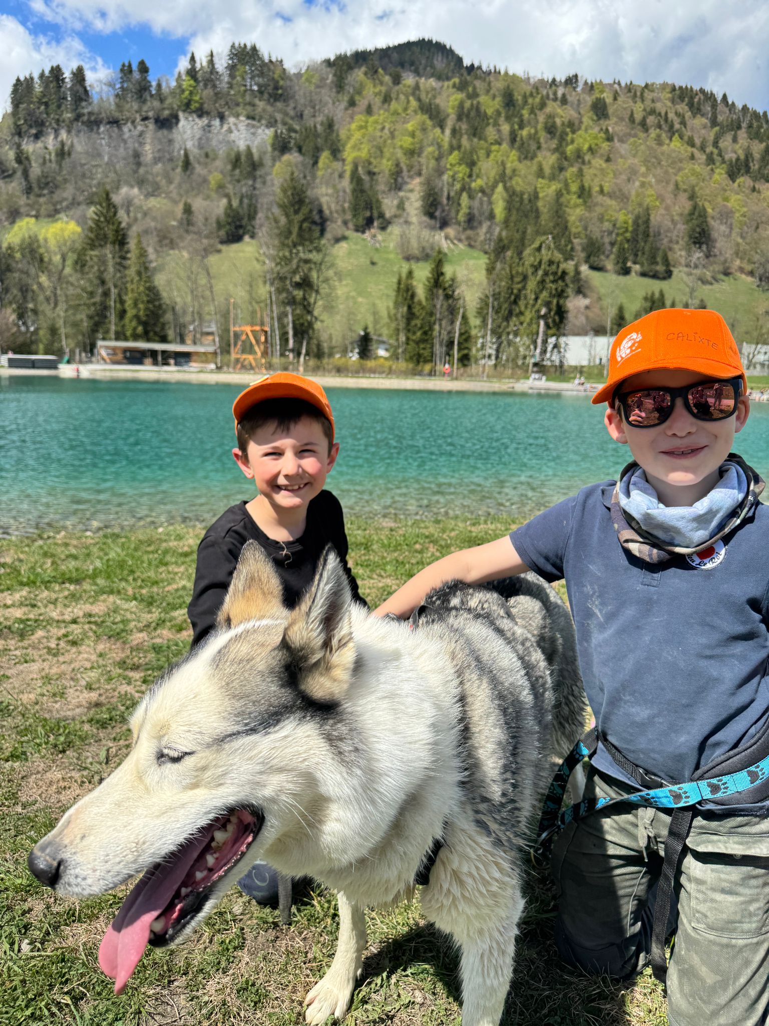 Deux enfants et un chien au bord du lac pendant une sortie nature
